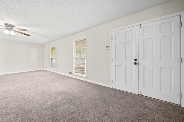 unfurnished bedroom featuring carpet floors, a textured ceiling, and ceiling fan