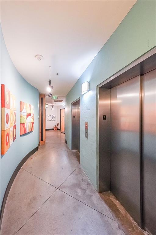 hallway with concrete flooring and elevator