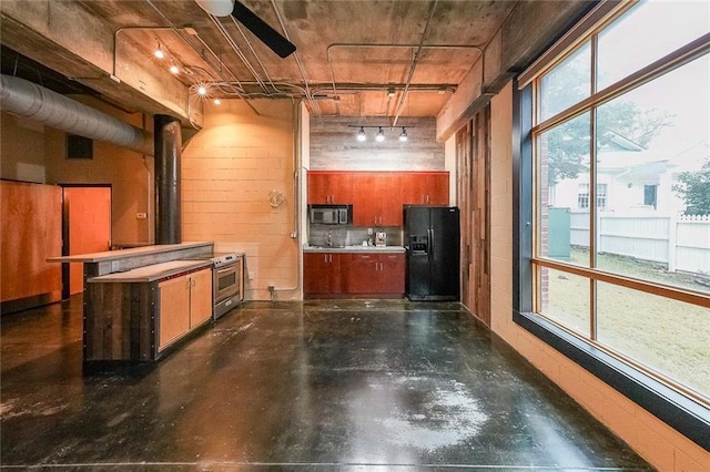 kitchen with finished concrete floors, visible vents, black fridge with ice dispenser, and hanging light fixtures