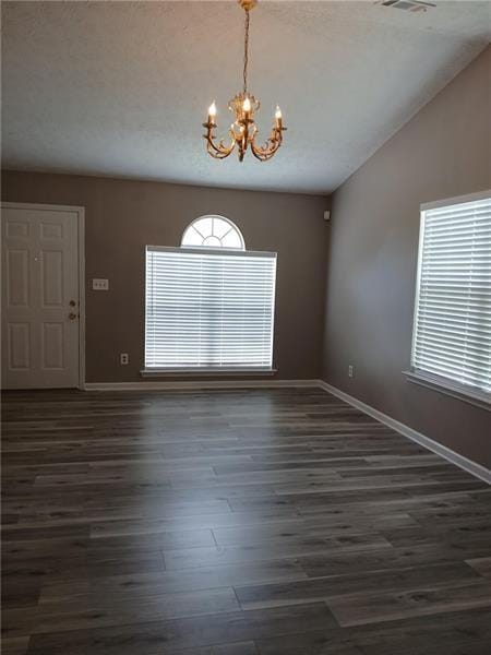 spare room featuring a chandelier, baseboards, wood finished floors, and vaulted ceiling