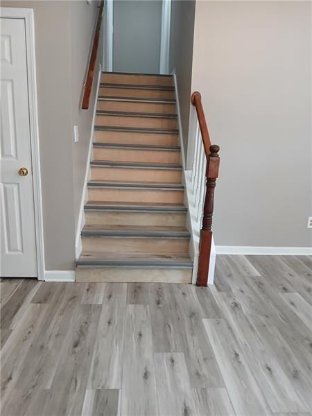 stairs with baseboards and wood finished floors