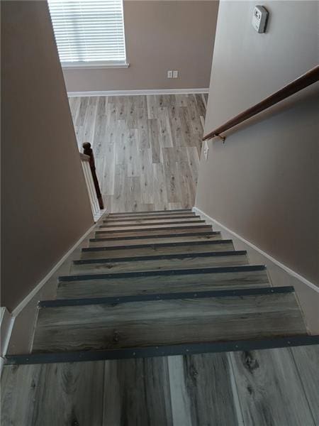 stairway featuring wood finished floors and baseboards