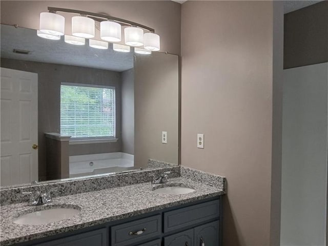 bathroom with double vanity and a garden tub