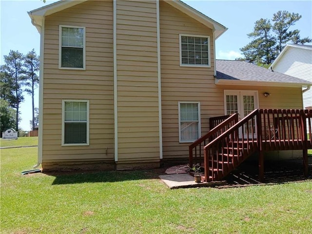 back of house with a deck, a yard, a shingled roof, and stairs