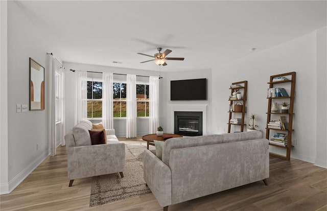 living room with wood-type flooring and ceiling fan