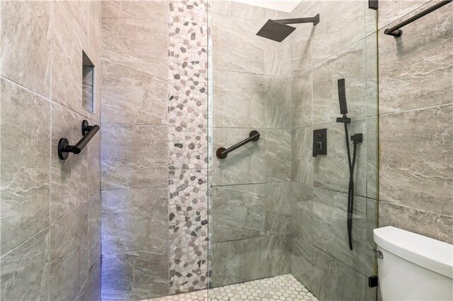 bathroom featuring toilet and tiled shower