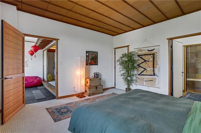 bedroom with wood ceiling, ensuite bath, and carpet flooring