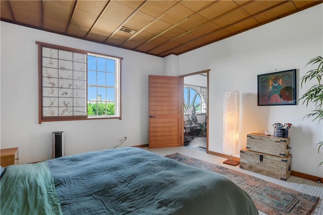 bedroom with wood ceiling and light colored carpet