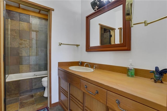 full bathroom with combined bath / shower with glass door, vanity, and toilet