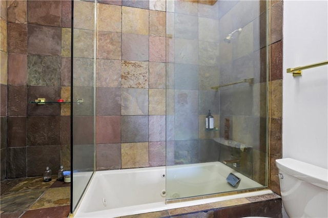 bathroom featuring tiled shower / bath combo and toilet