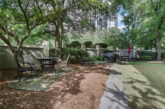 view of community featuring a lawn and a patio area