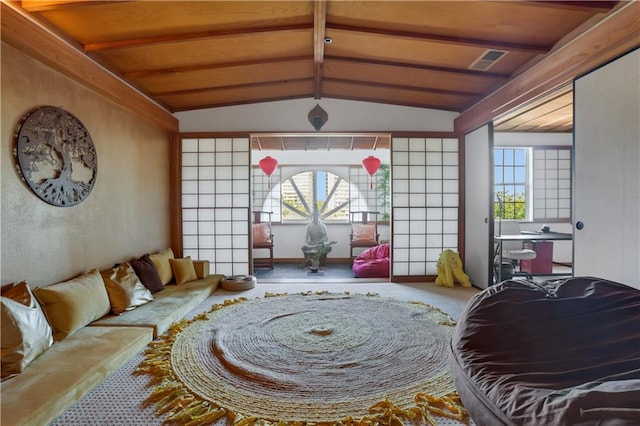 carpeted living room featuring vaulted ceiling with beams and a wealth of natural light