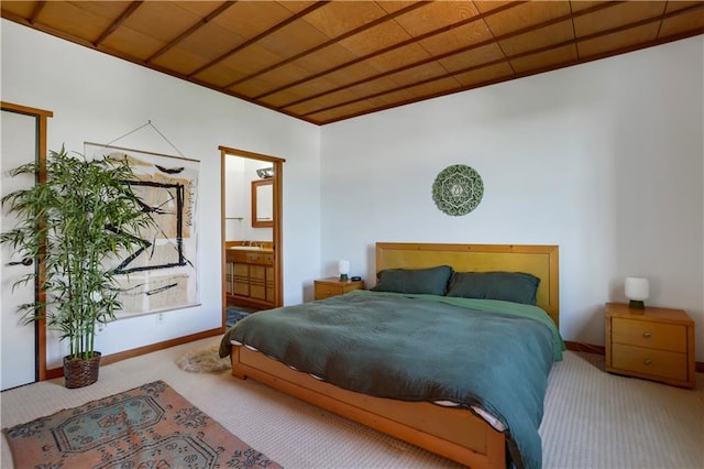 bedroom featuring ensuite bath, carpet floors, and sink