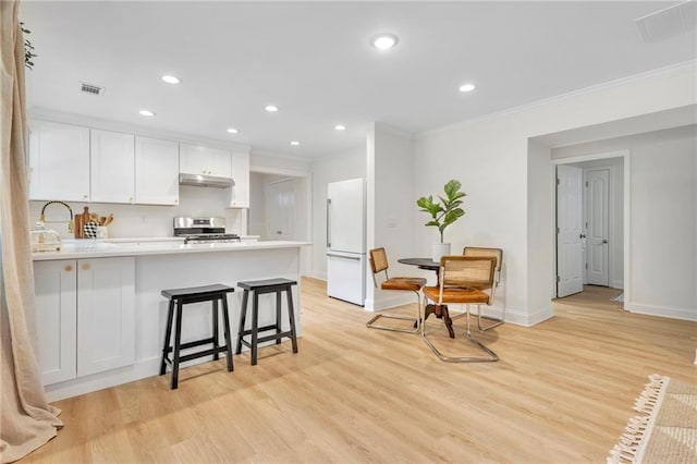 5601 Due W Rd, Powder Springs, GA 30127 - kitchen featuring stainless steel range with electric stovetop, freestanding refrigerator, under cabinet range hood, ornamental molding, and a peninsula