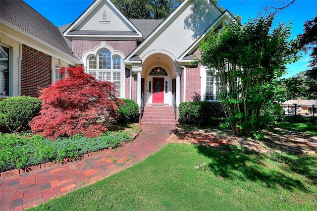 1595 Lake Lucerne Rd SW, Lilburn, GA 30047 - view of front of home with brick siding, a front yard, and stucco siding