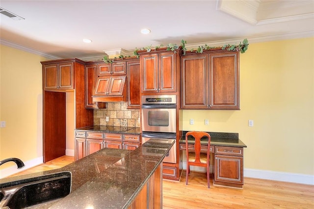 1595 Lake Lucerne Rd SW, Lilburn, GA 30047 - kitchen featuring stainless steel double oven, a sink, light wood-style floors, tasteful backsplash, and crown molding