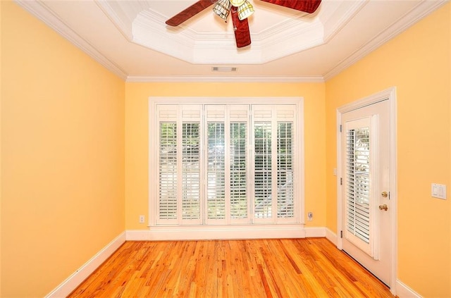 1595 Lake Lucerne Rd SW, Lilburn, GA 30047 - spare room with a tray ceiling, crown molding, light wood-style flooring, a ceiling fan, and baseboards