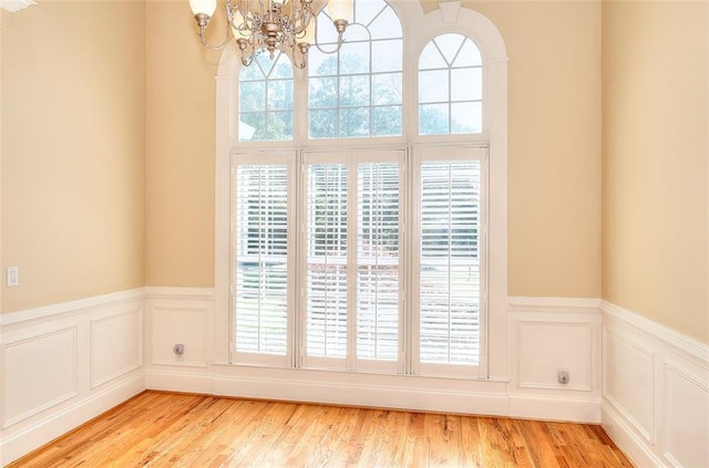 1595 Lake Lucerne Rd SW, Lilburn, GA 30047 - detailed view of a chandelier, a wainscoted wall, wood finished floors, and a decorative wall