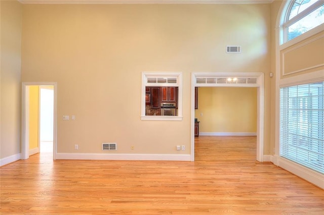 1595 Lake Lucerne Rd SW, Lilburn, GA 30047 - spare room featuring a towering ceiling, light wood-style floors, and baseboards