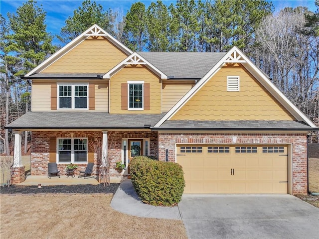 craftsman-style house with driveway, brick siding, a porch, and an attached garage