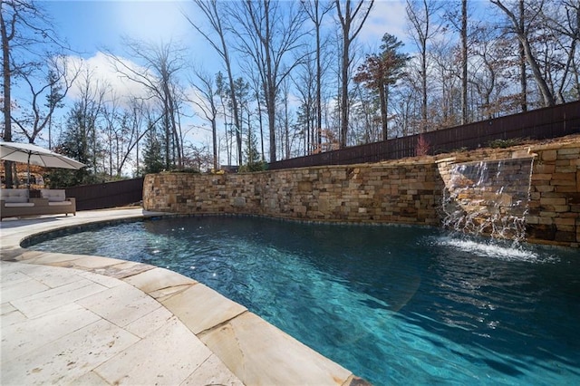 view of pool with a patio, an outdoor living space, and pool water feature