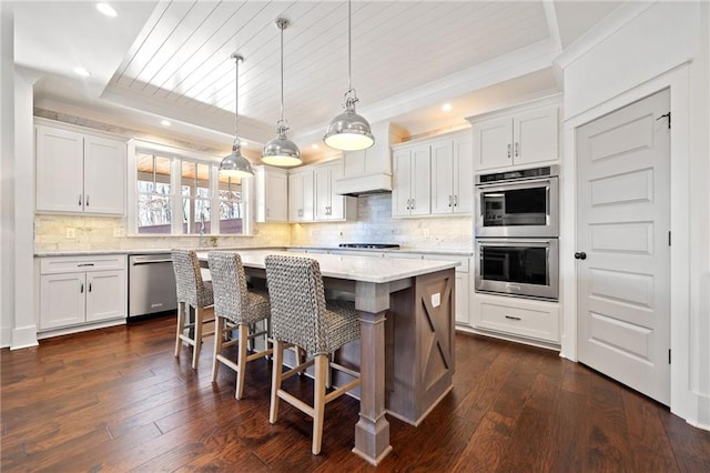 kitchen featuring a kitchen island, appliances with stainless steel finishes, a breakfast bar area, and white cabinets