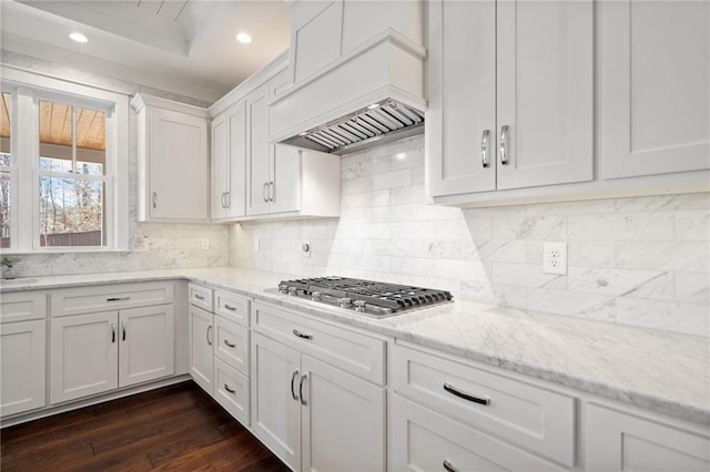 kitchen with white cabinetry, dark hardwood / wood-style floors, light stone counters, custom exhaust hood, and stainless steel gas stovetop