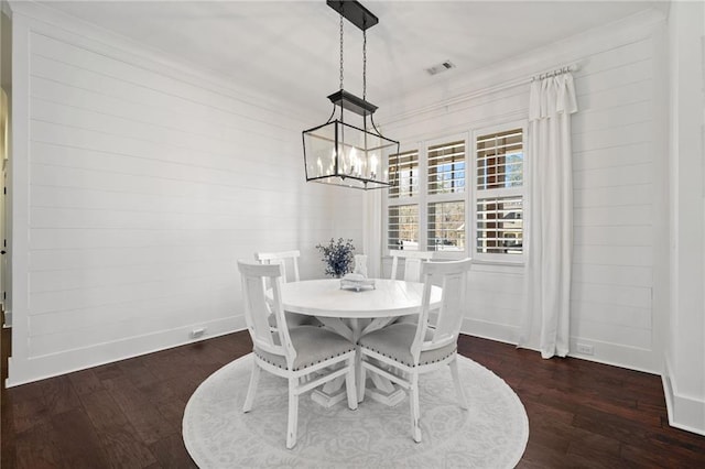 dining room with dark hardwood / wood-style floors and a notable chandelier