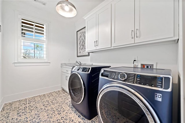 laundry room featuring cabinets, washing machine and dryer, and sink