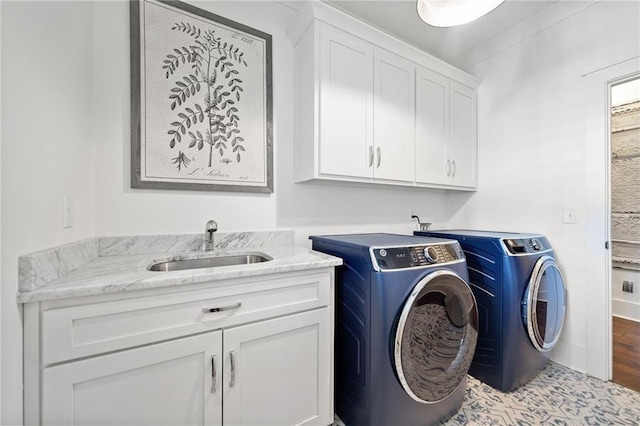 laundry room featuring cabinets, separate washer and dryer, and sink