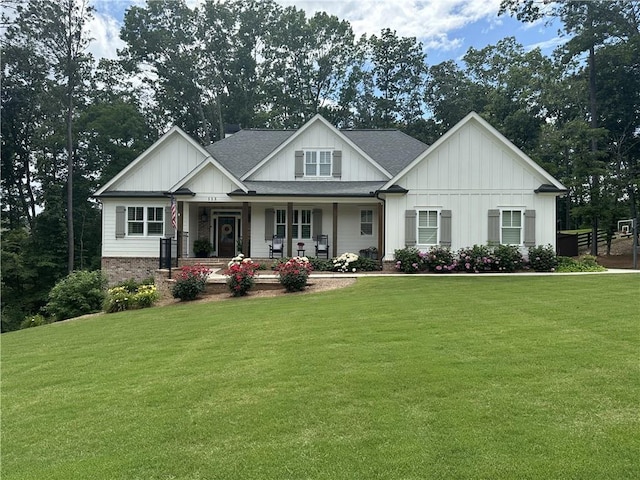 craftsman-style home featuring covered porch and a front lawn