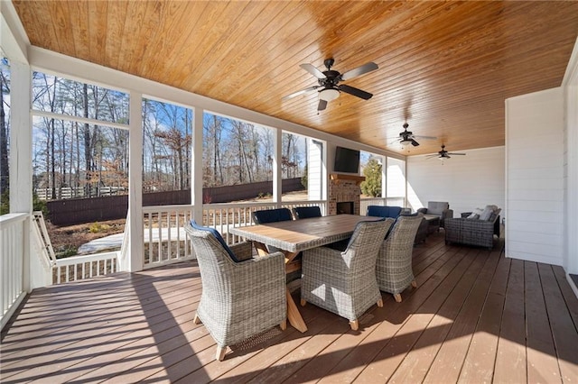 sunroom with an outdoor brick fireplace and wooden ceiling