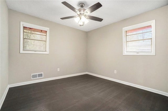 spare room featuring a ceiling fan, visible vents, and baseboards