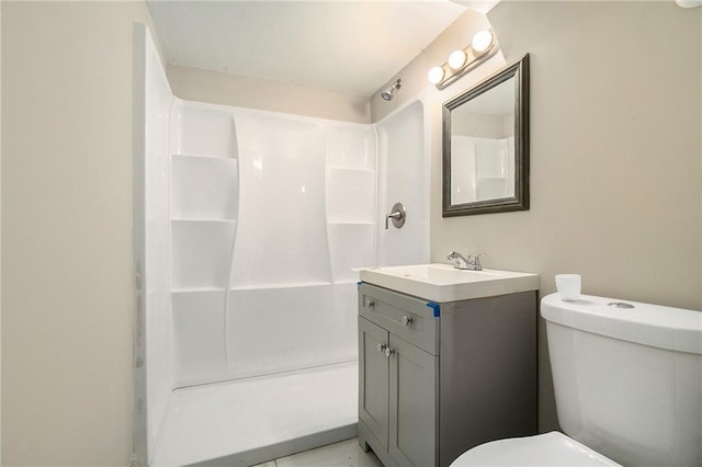 bathroom featuring toilet, a shower, and vanity