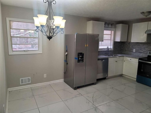 kitchen featuring sink, stainless steel appliances, white cabinetry, and pendant lighting