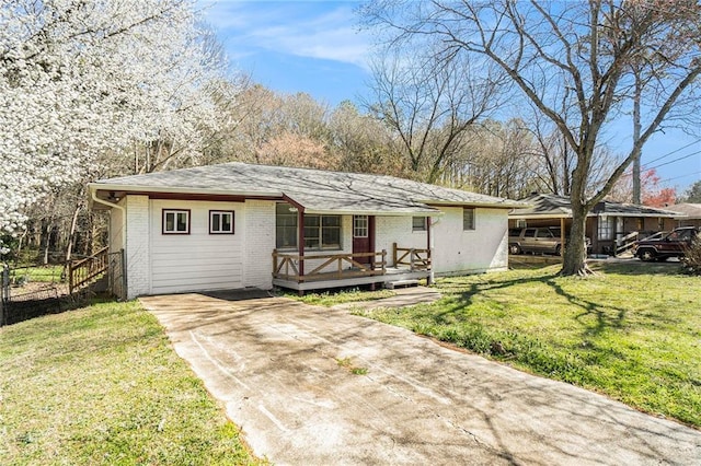 single story home featuring a front yard, brick siding, and a deck