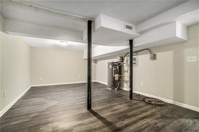 finished basement featuring baseboards, water heater, visible vents, and wood finished floors