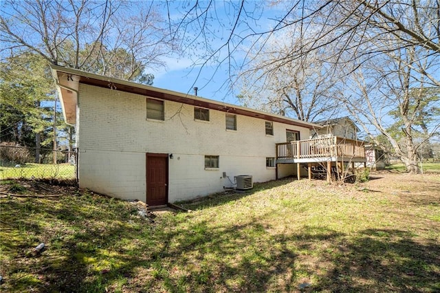 rear view of house with brick siding, a yard, central AC, fence, and a deck