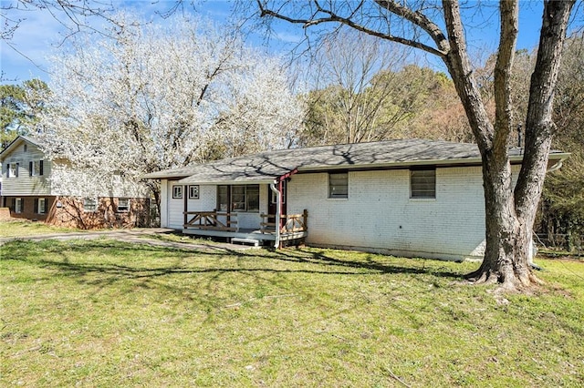 exterior space with a deck, a front lawn, and brick siding