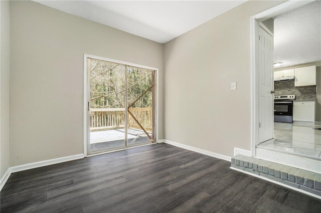 unfurnished room featuring baseboards and wood finished floors