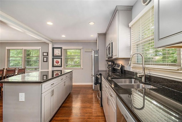 6590 Williamson Dr NE, Atlanta, GA 30328 - kitchen featuring a center island, stainless steel appliances, a sink, crown molding, and dark stone counters