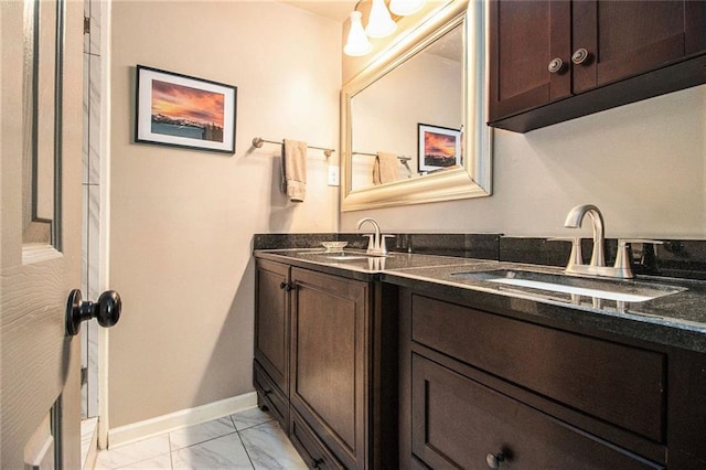 6590 Williamson Dr NE, Atlanta, GA 30328 - bathroom featuring marble look tile flooring, double vanity, and baseboards
