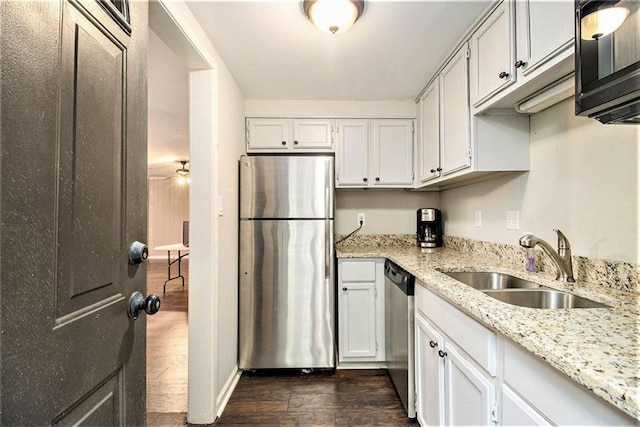 6590 Williamson Dr NE, Atlanta, GA 30328 - kitchen with appliances with stainless steel finishes, a sink, dark wood-style floors, light stone countertops, and white cabinets