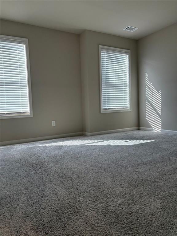 carpeted empty room featuring visible vents and baseboards