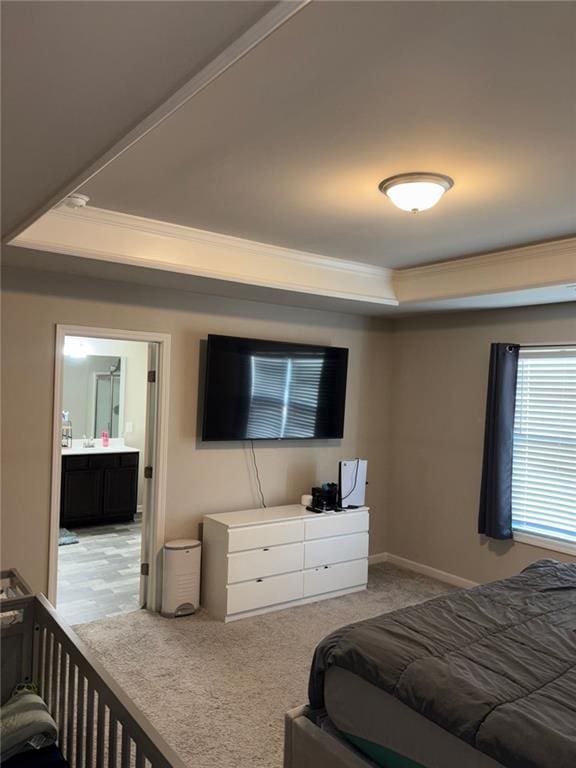 bedroom featuring ornamental molding, a raised ceiling, and baseboards