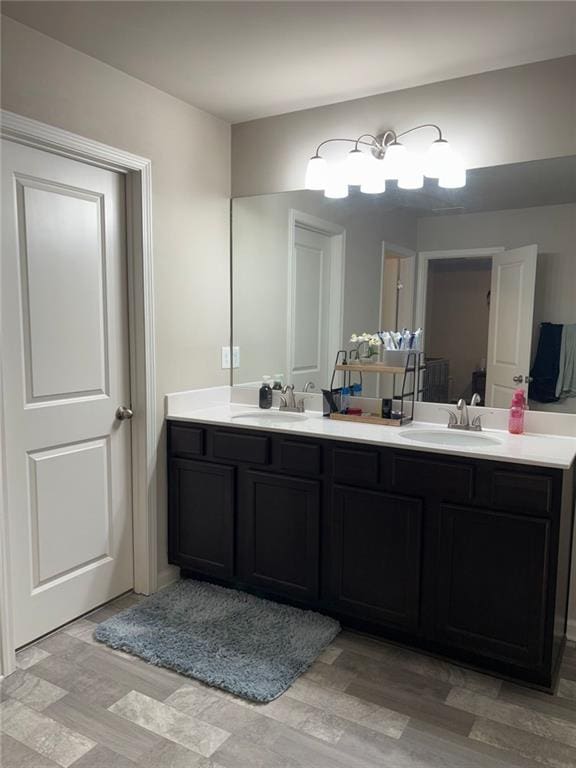 bathroom featuring double vanity, a sink, and wood finished floors