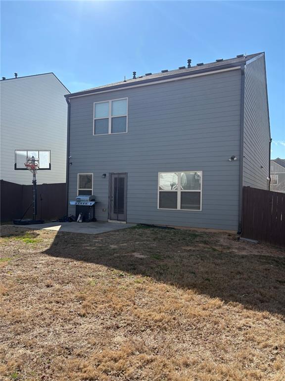 back of house featuring a yard, a patio, and fence