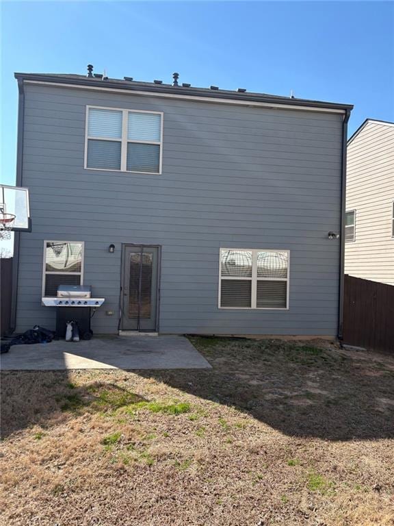 rear view of property with a yard, fence, and a patio