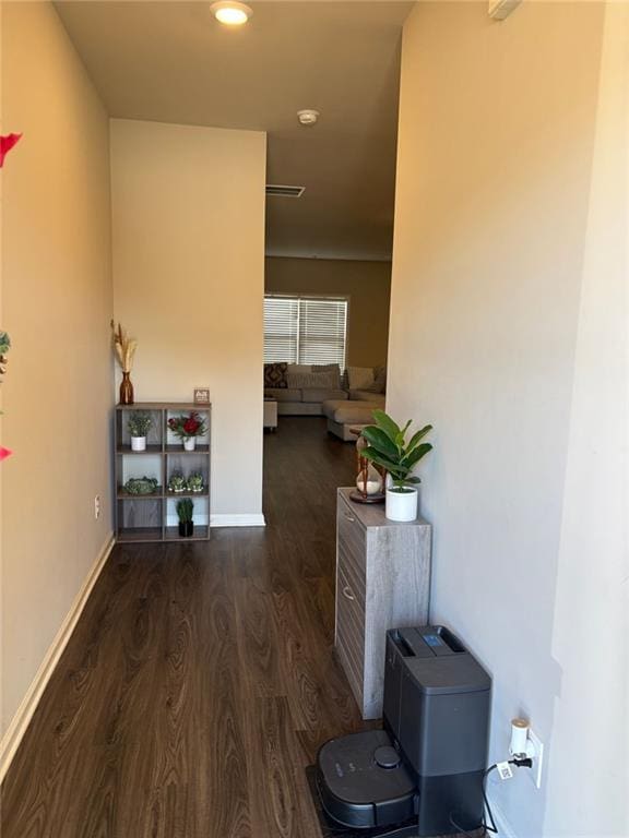 corridor with visible vents, baseboards, and wood finished floors