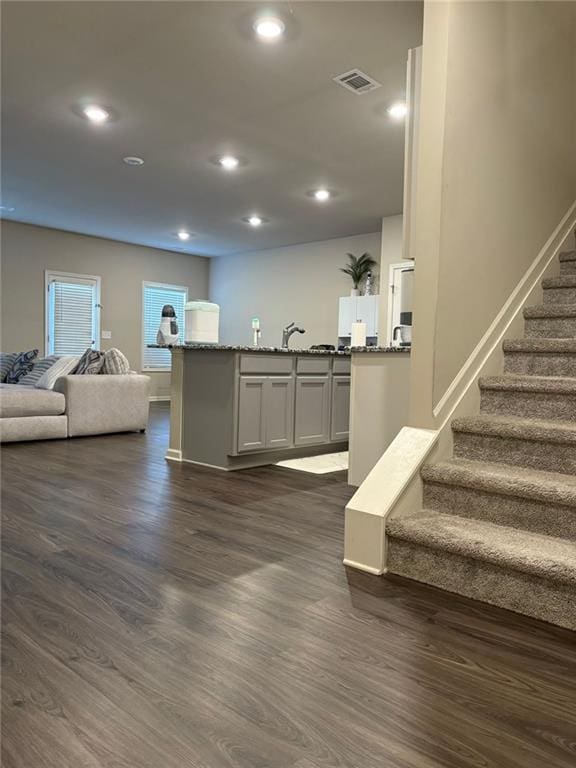 interior space featuring stairs, visible vents, dark wood finished floors, and recessed lighting